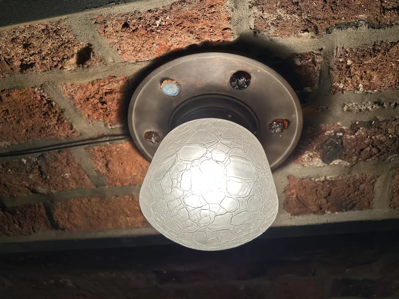 plafonnier avec ampoule blanche sur plafond en brique