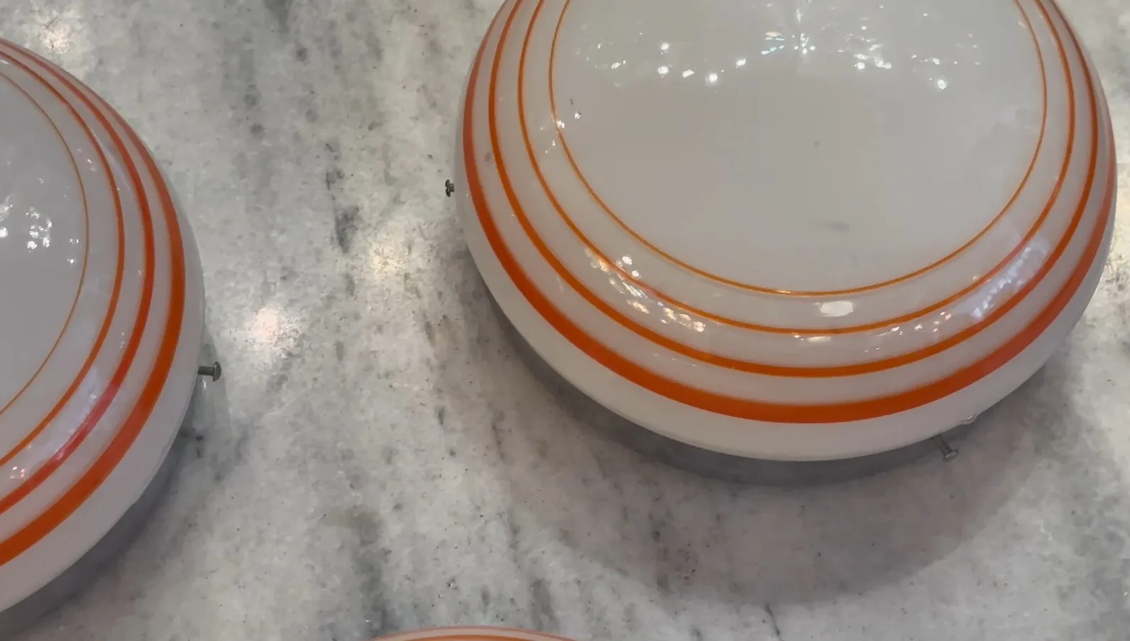 tres plafones antiguos con detalles en naranja sobre una superficie clara