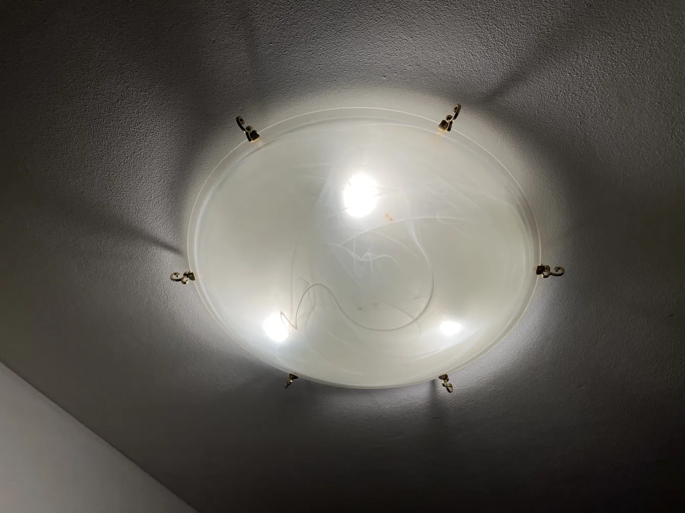 Plafoniere antiche con illuminazione soffusa, atmosfera classica.