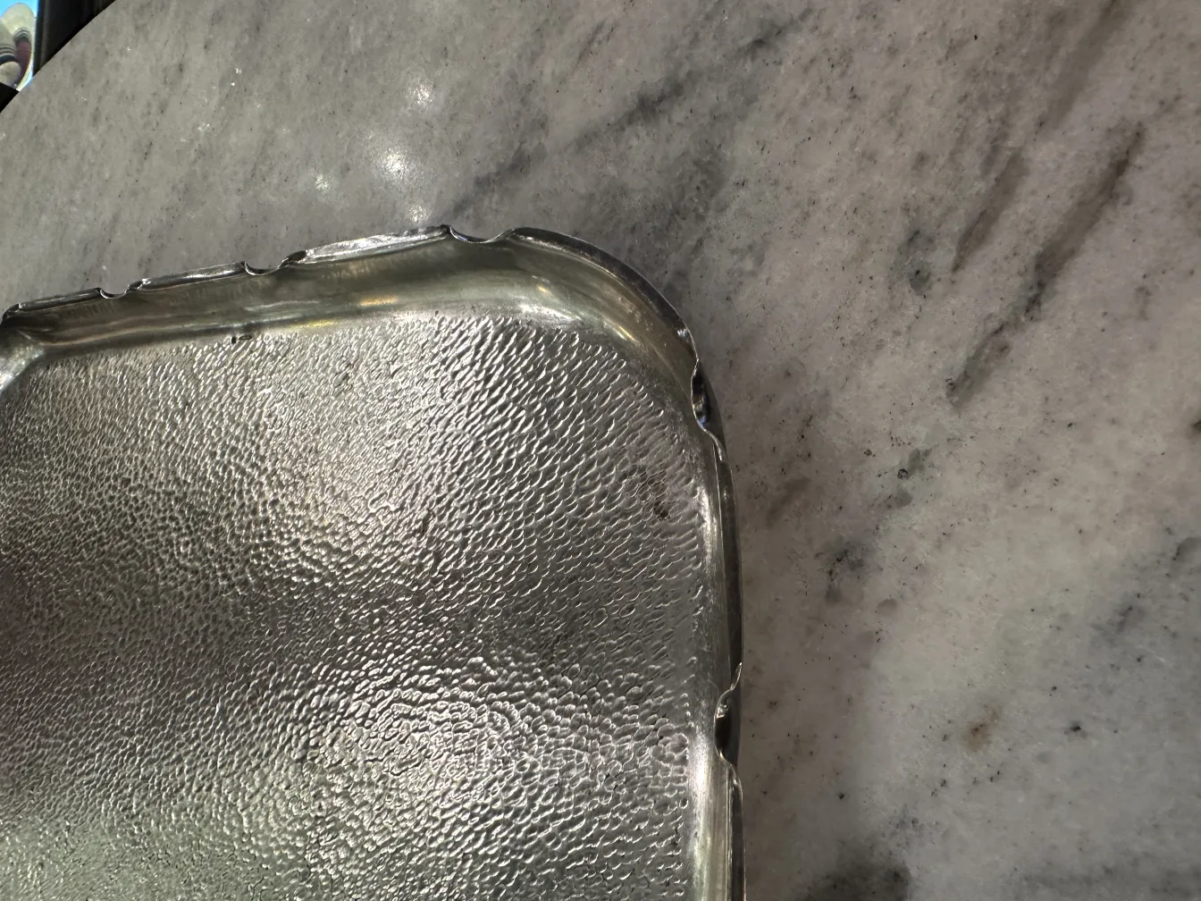 bandeja antigua con bordes decorativos sobre superficie