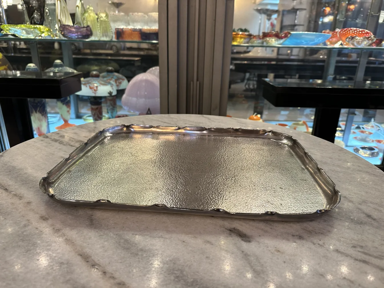 ancien plateau avec finition brillante et bords ondulés sur une table en marbre