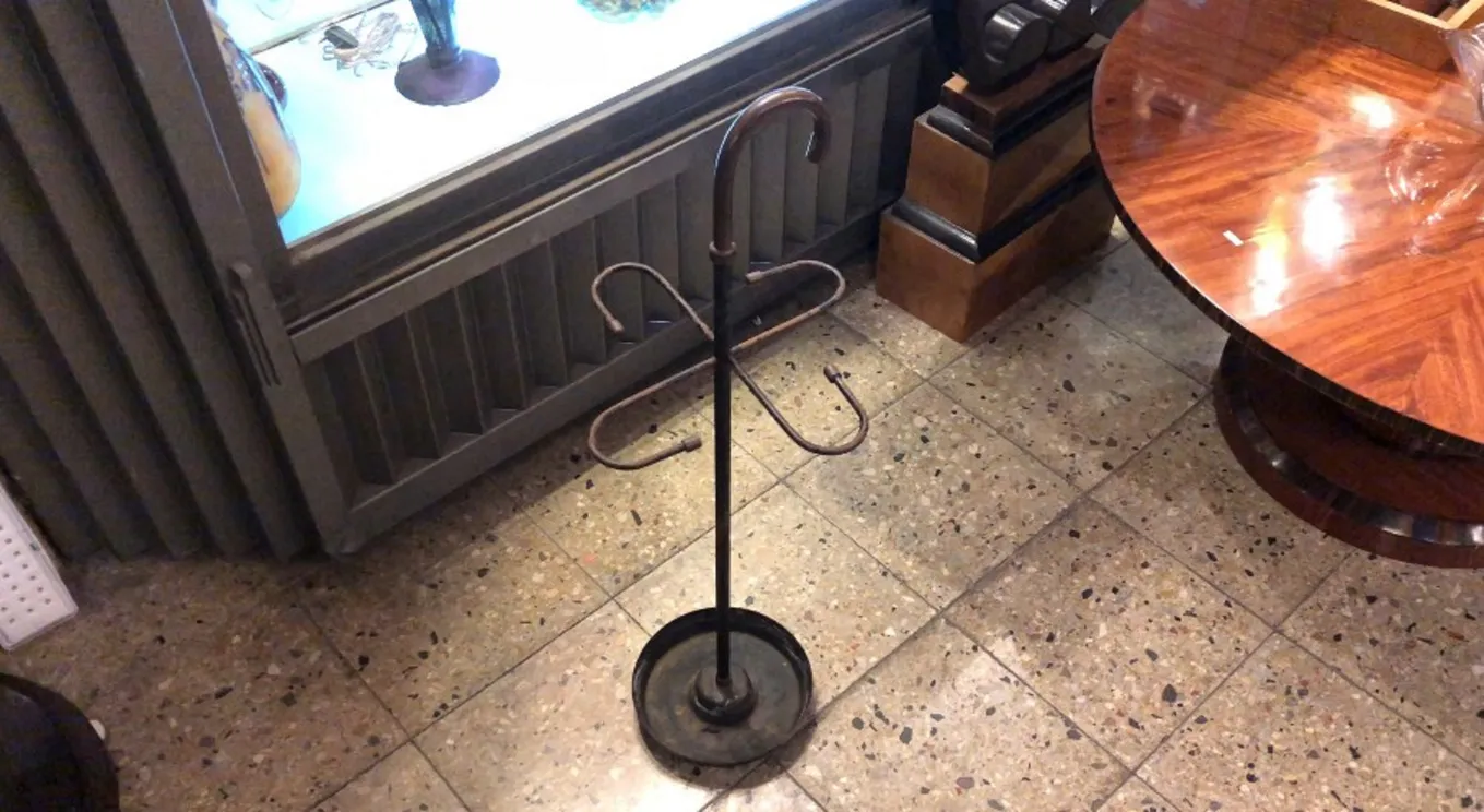 حامل مظلات قديم بتصميم زخرفي في بيئة كلاسيكية.