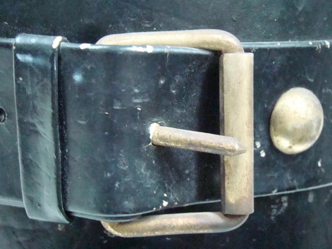 Antique umbrella stand with buckle detail and dark background