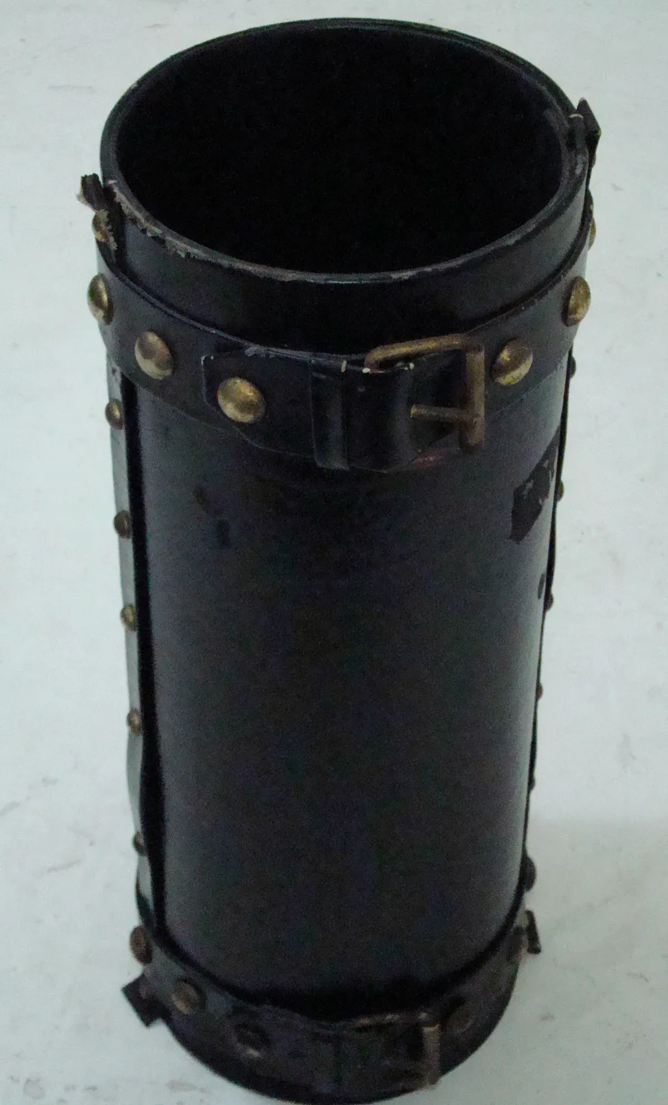 antique black cylindrical umbrella stand, decorated, in a neutral environment