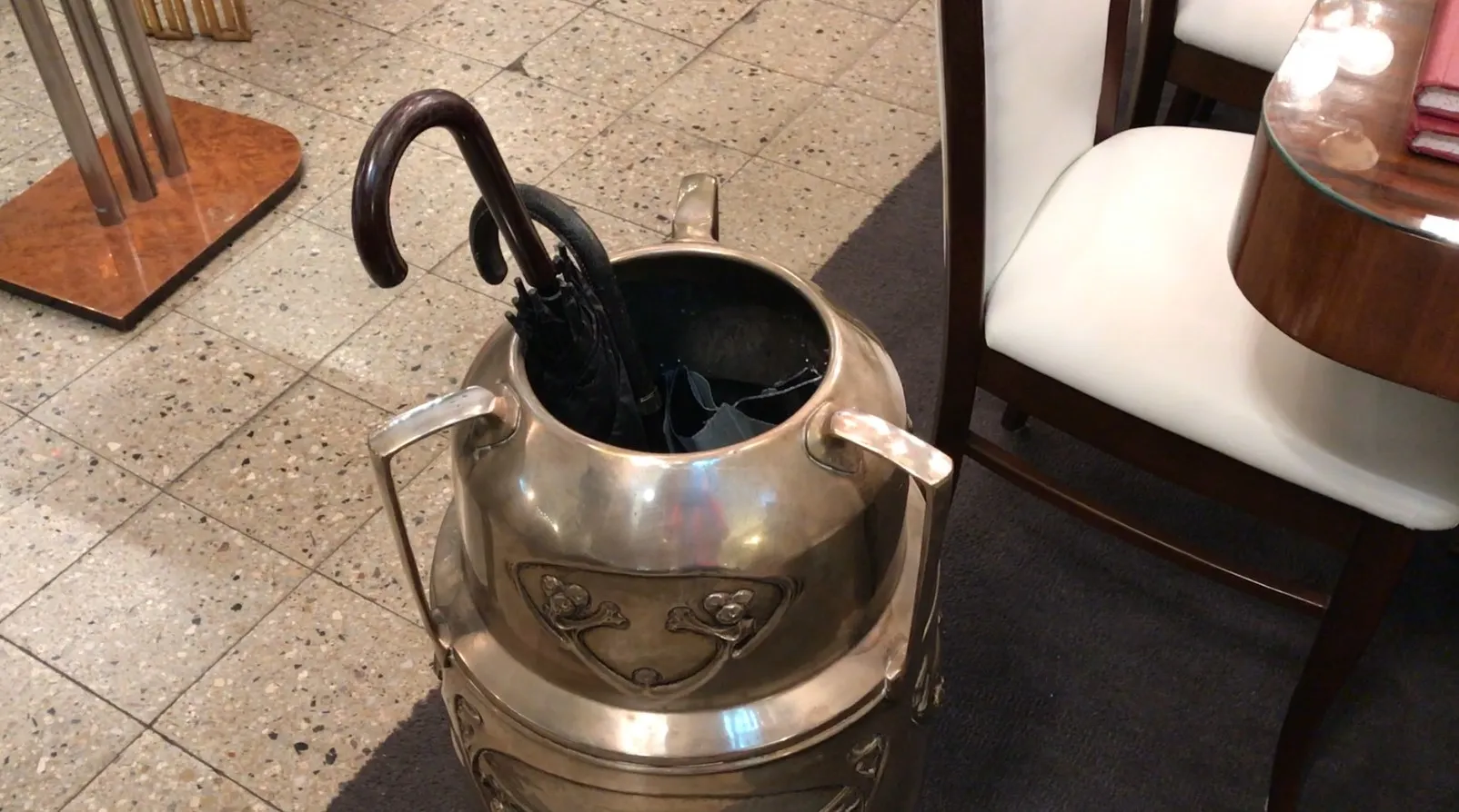 antique umbrella stand with umbrellas in various colors and shapes