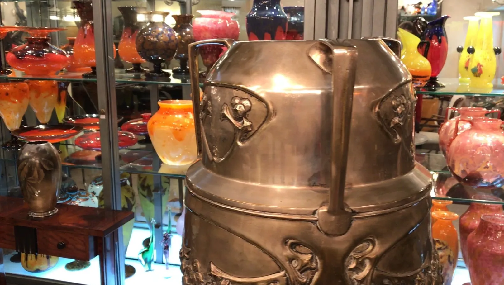 porte-parapluie ancien décoratif dans une vitrine avec d'autres antiquités