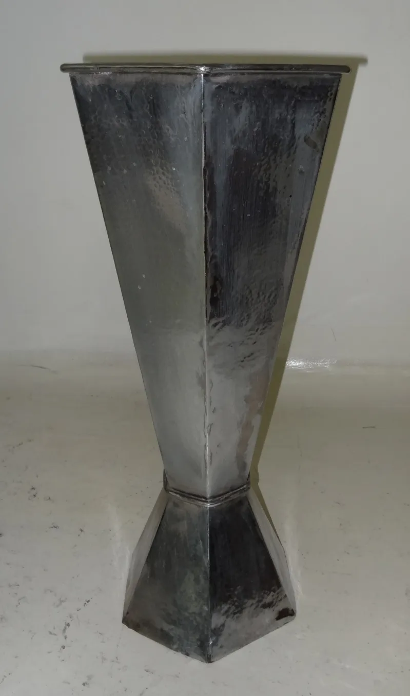 Antique umbrella stand with an elegant shape and shiny surface, in a neutral setting.