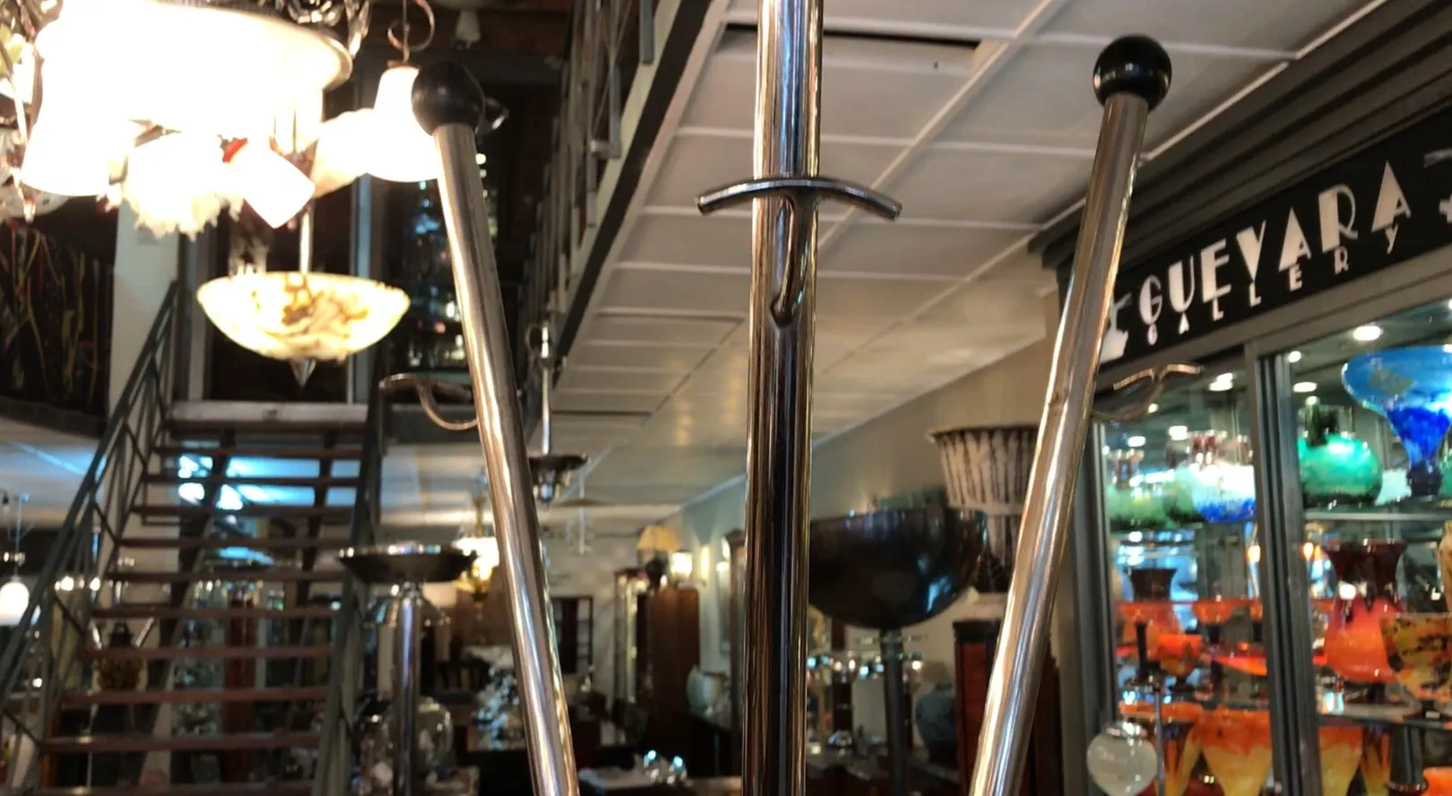 Bengaleiro antigo em uma galeria iluminada, com acessórios decorativos ao redor.