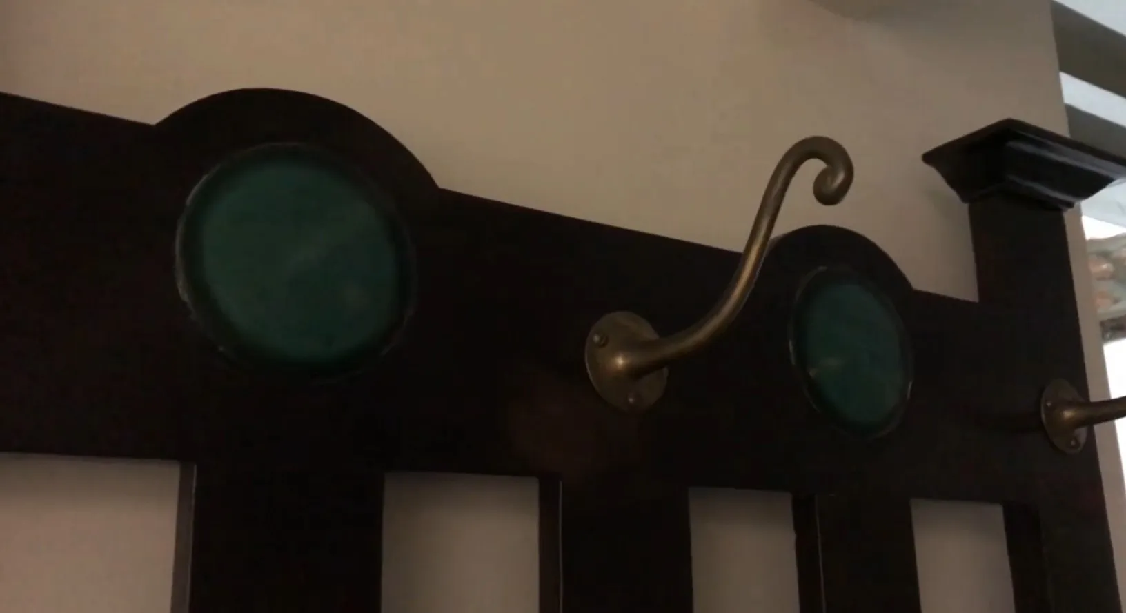 bengaleiro antigo com ganchos decorativos em ambiente neutro