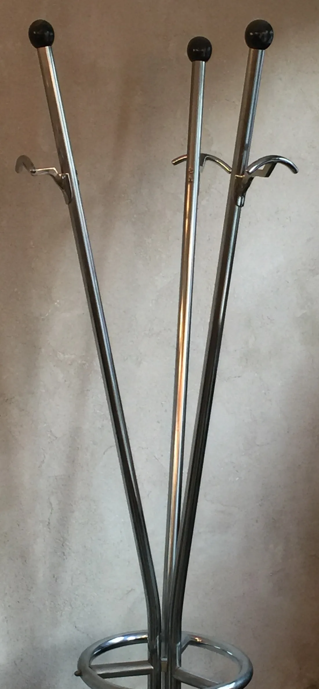 Antique coat rack with multiple hooks, neutral background.