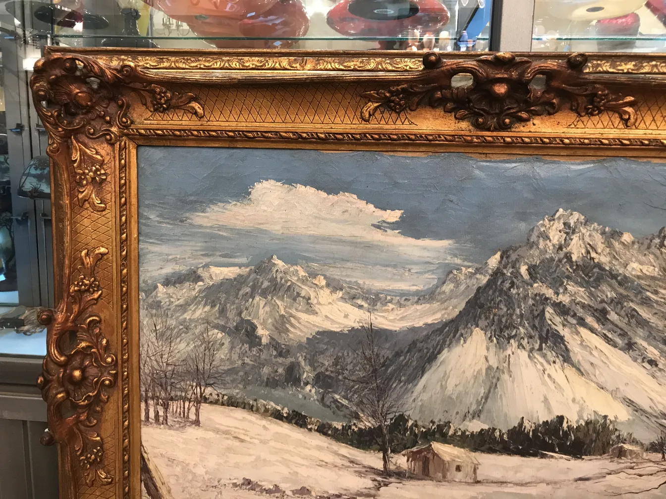 Pintura Crispino mostrando un paisaje montañoso, con un marco ornamentado, en un entorno antiguo.