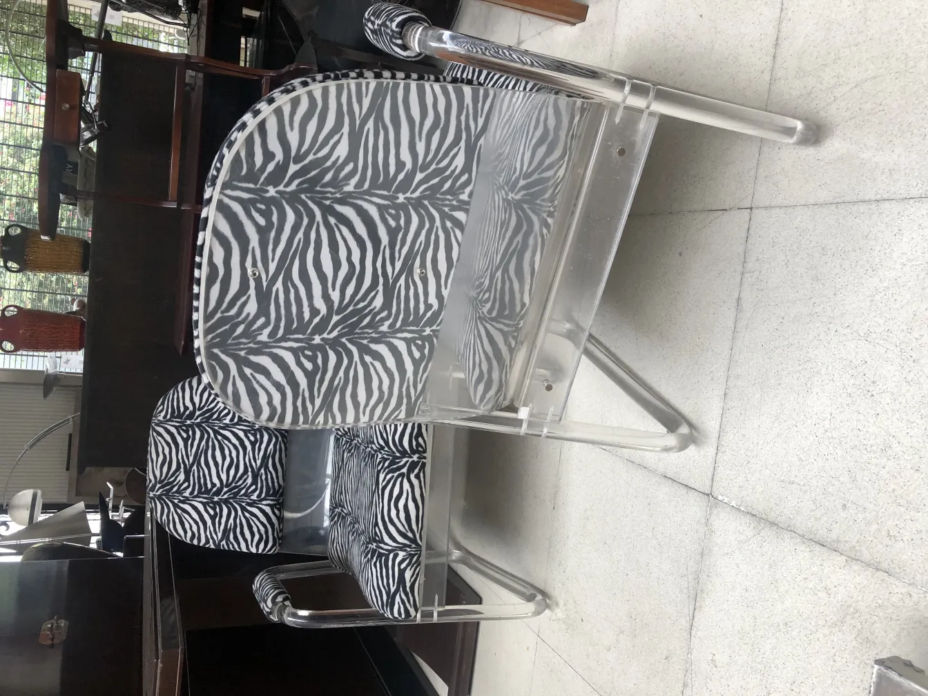 Duas poltronas antigas com design de zebra, confortáveis e decorativas em um ambiente elegante.