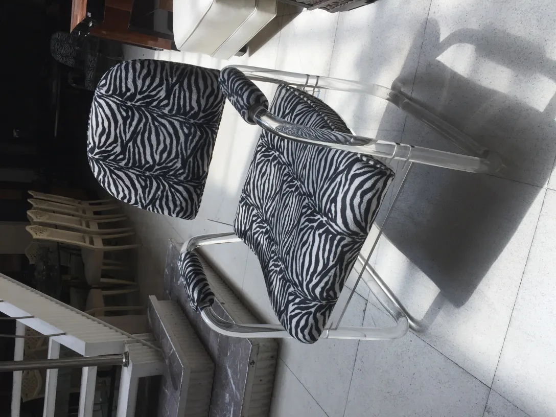 dos sillones antiguos con estampado de cebra en el diseño, en un ambiente acogedor.