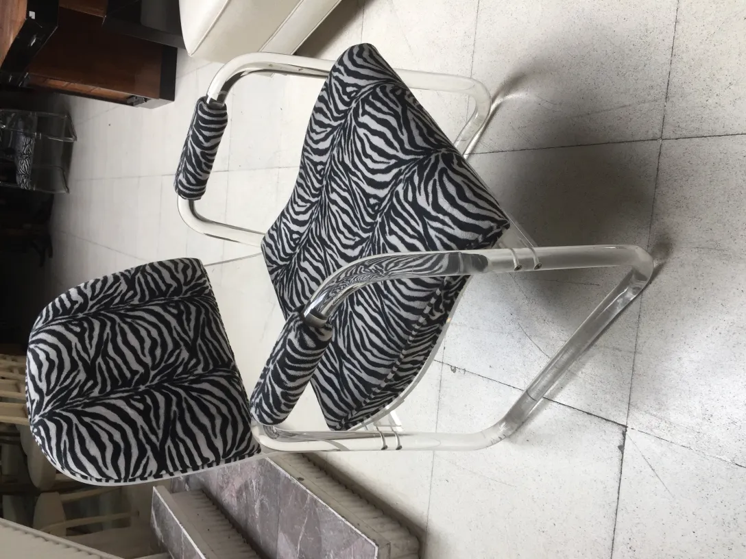 Deux fauteuils anciens avec un motif zèbre dans un cadre accueillant.