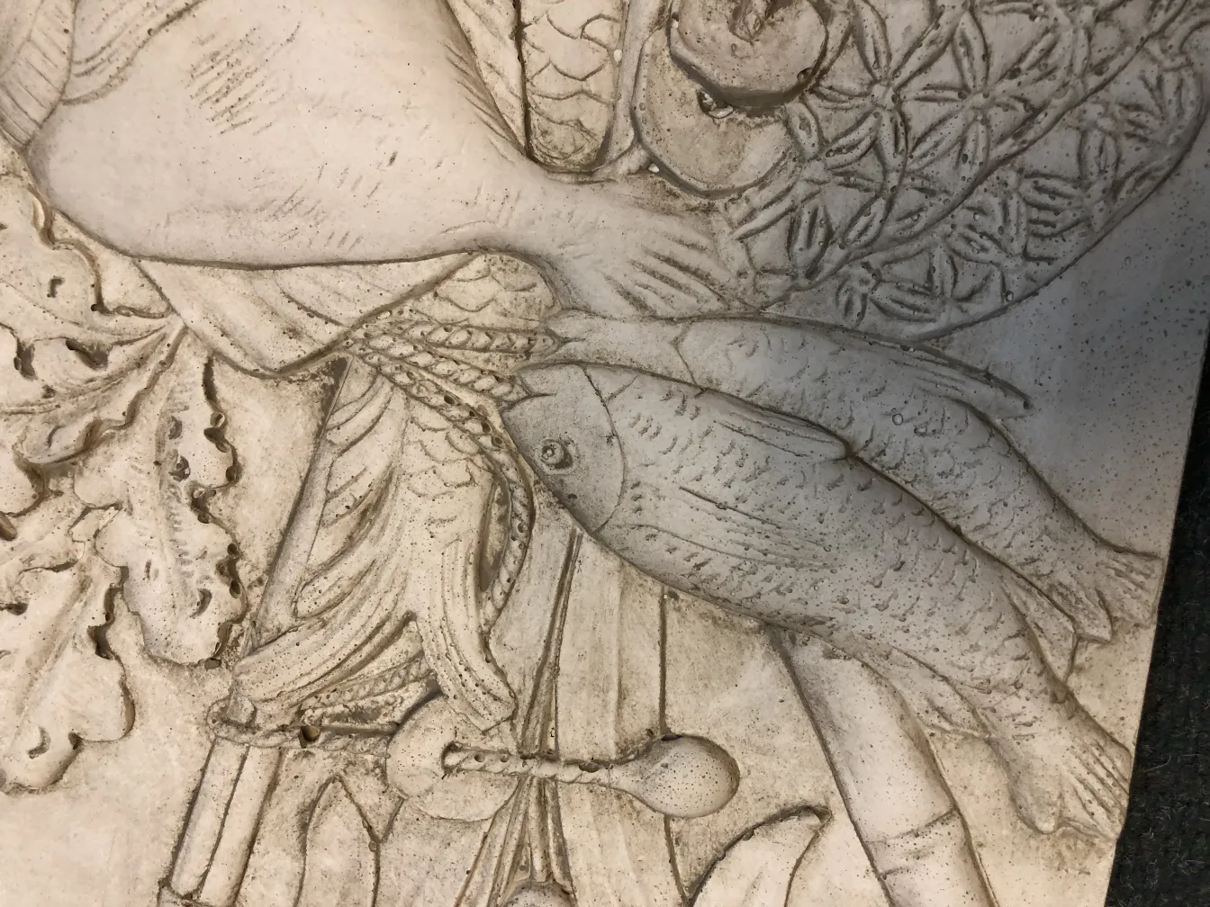 古いウォールプレートに彫刻された魚と装飾的な詳細デザイン。