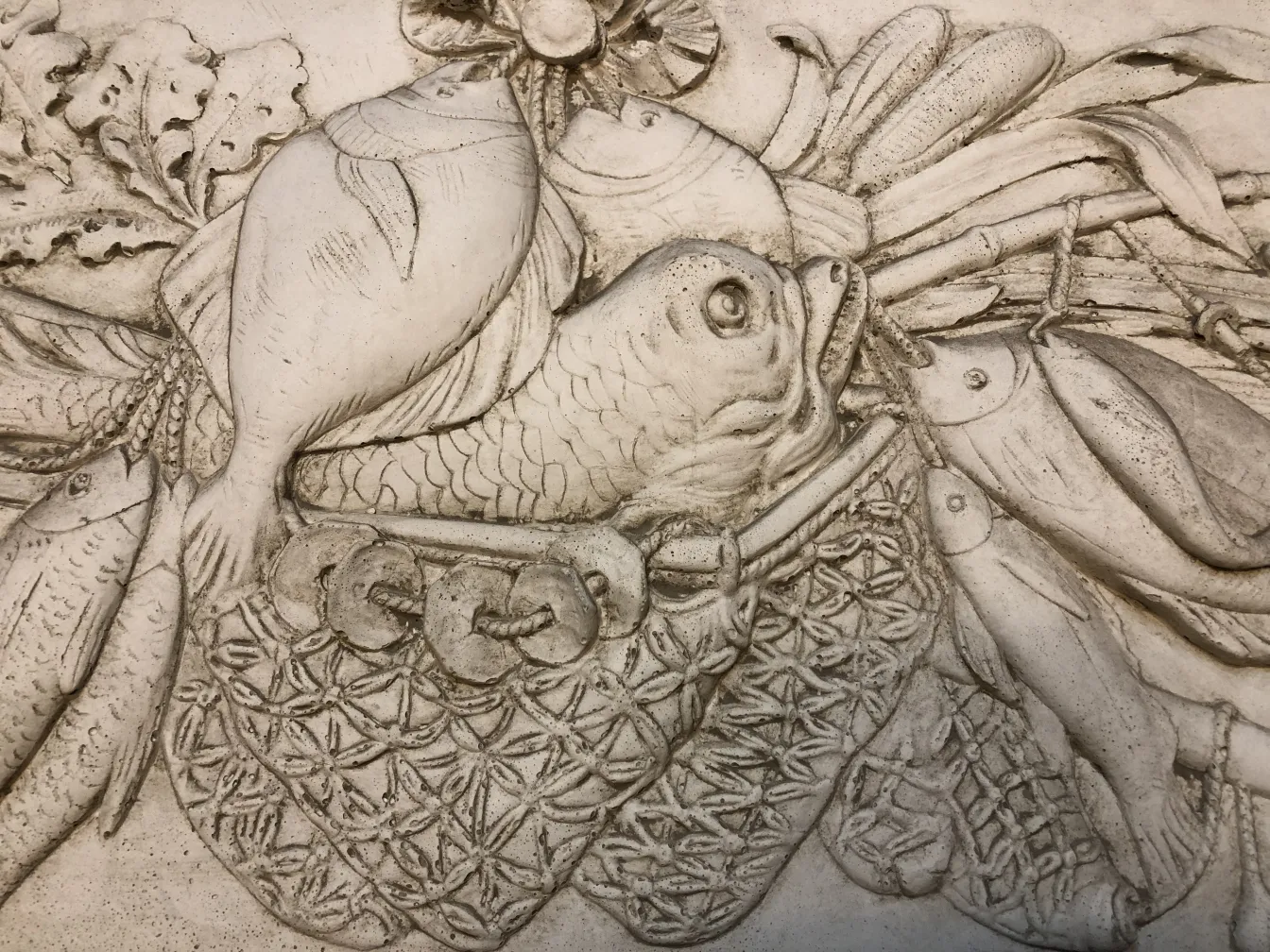 detalle de una placa de pared antigua con peces y decoración