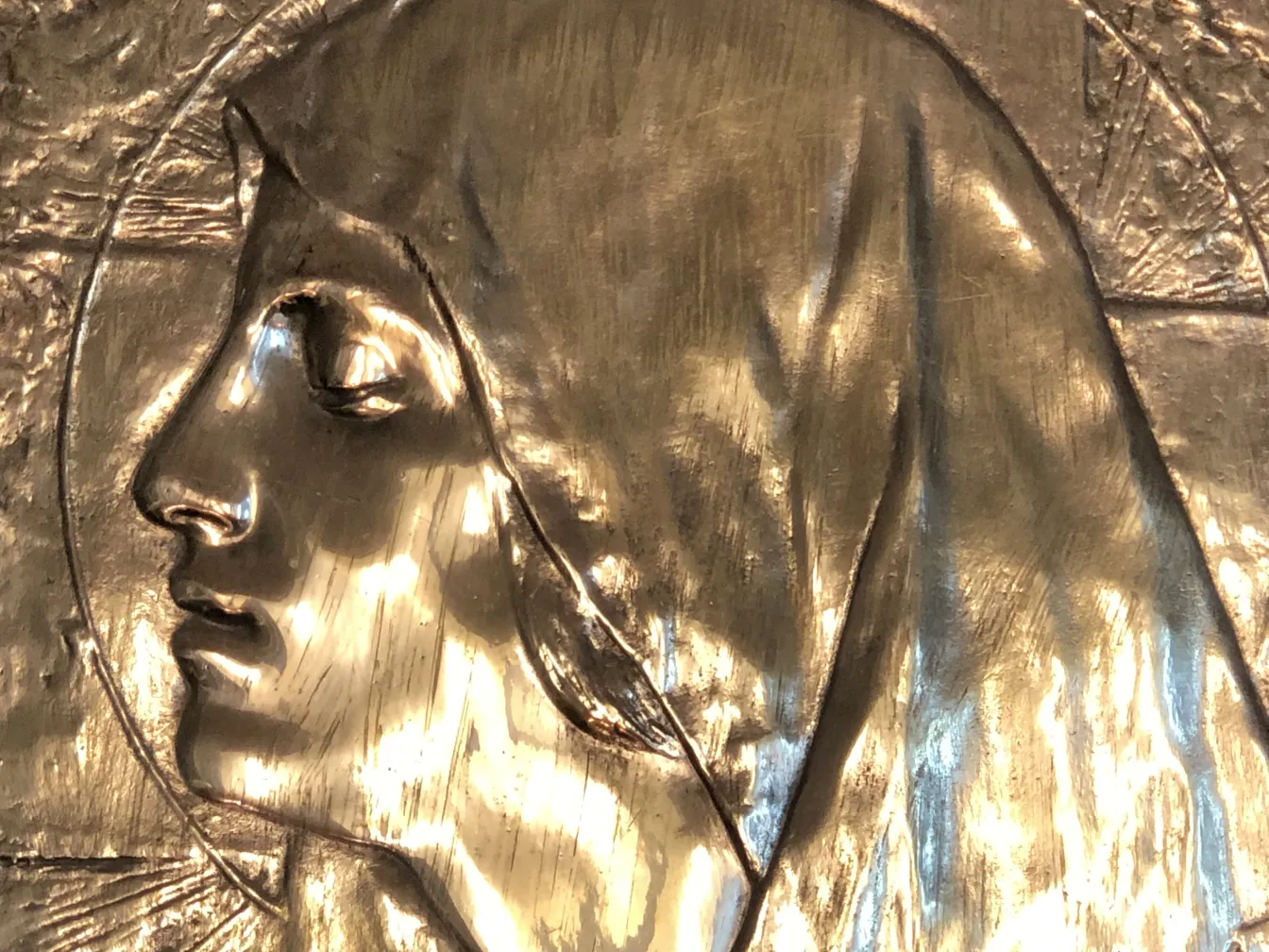 Placca a muro antica con ritratto in rilievo, dettagliata e lucida. Atmosfera artistica.