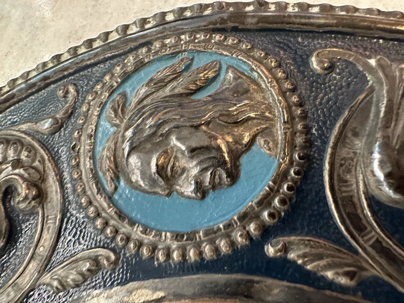 Placca a muro antica con ritratto in rilievo su sfondo blu