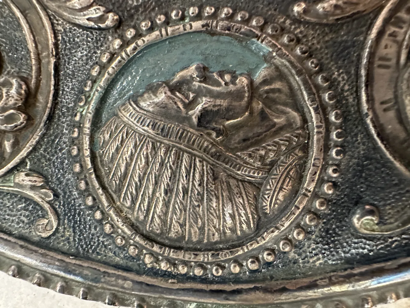 Dettaglio di una placca a muro antica con dettagli in rilievo intricati e un design unico.