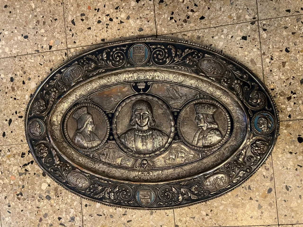 placa de parede antiga com retratos em relevo e fundo decorativo