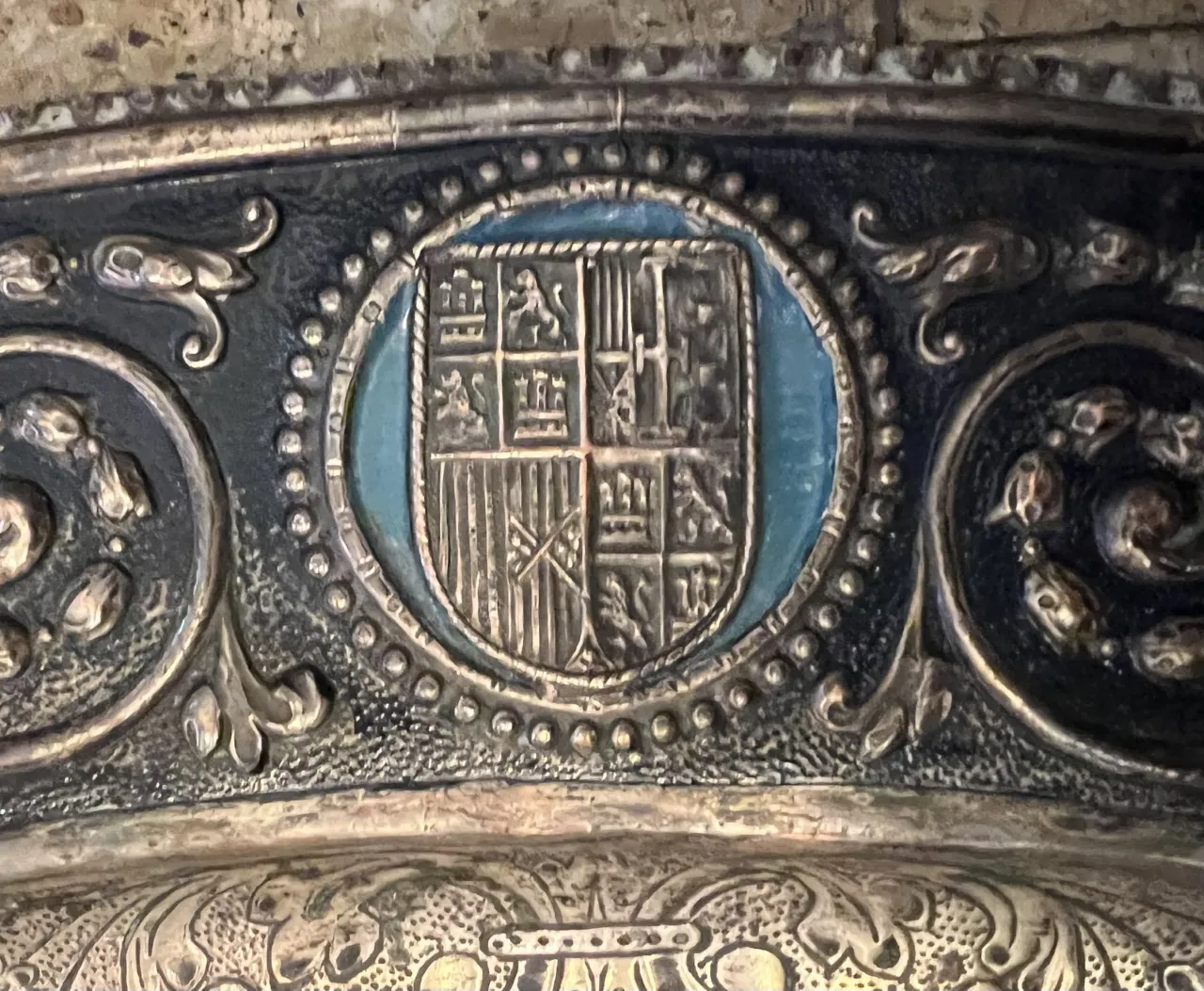 Intricate details on the vintage wall plate with shield, blue background.