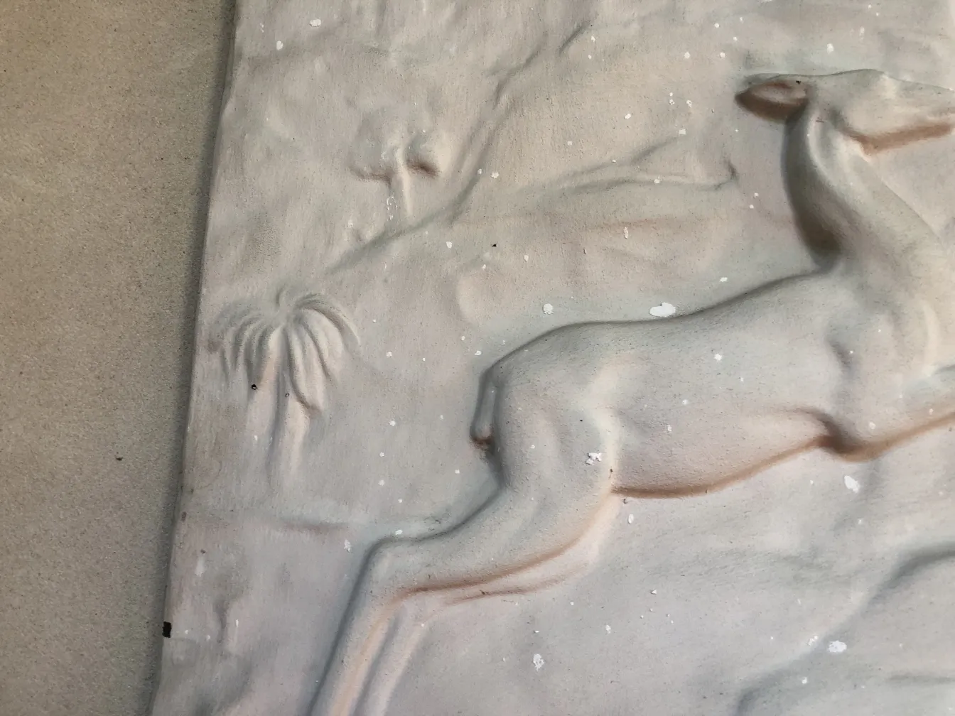 Antique wall plate featuring a deer and palm trees