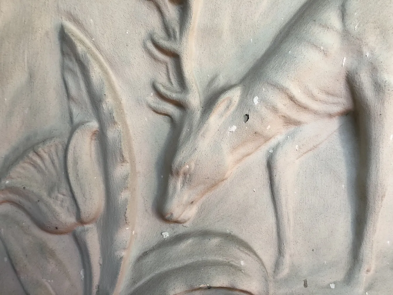 detail einer antiken Wandplatte mit Hirschrelief zwischen Blättern