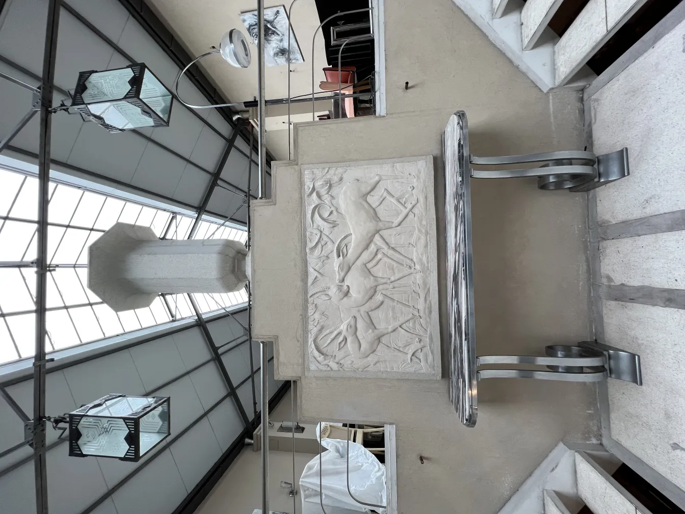 Plaque murale ancienne avec relief et motifs décoratifs, avec une lumière d'ambiance autour.