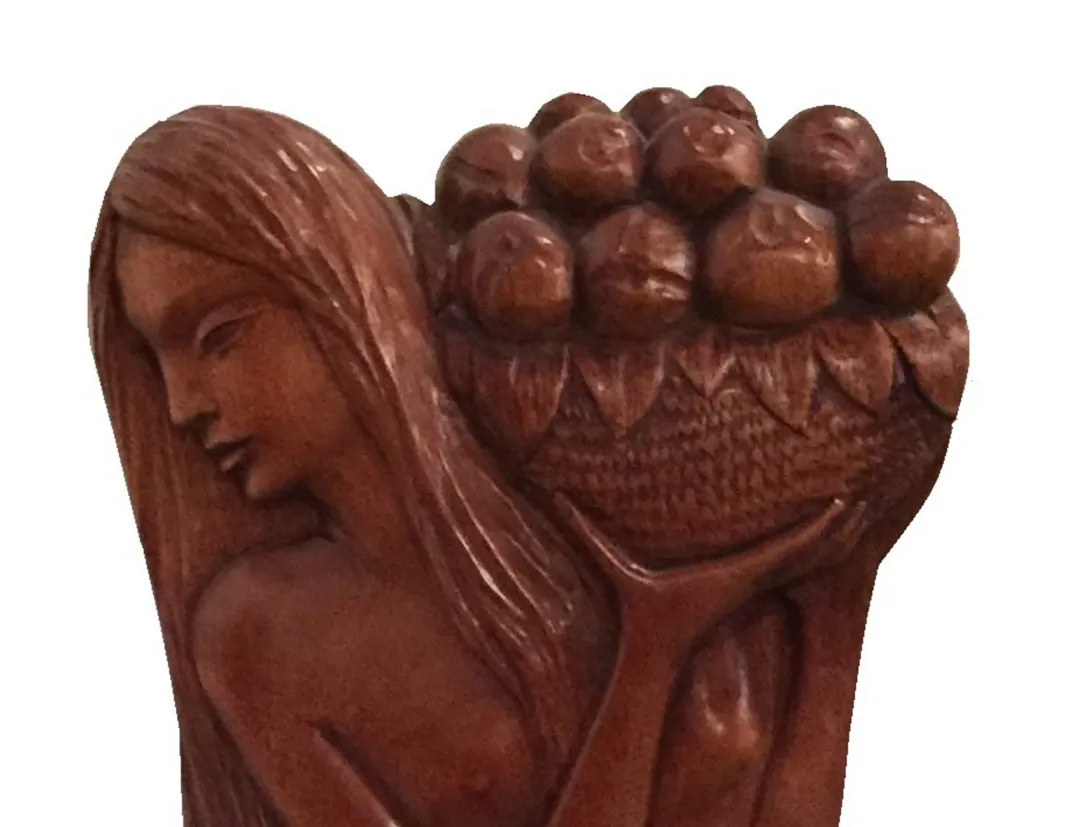 Placca a muro antica con scultura di donna che tiene frutti.