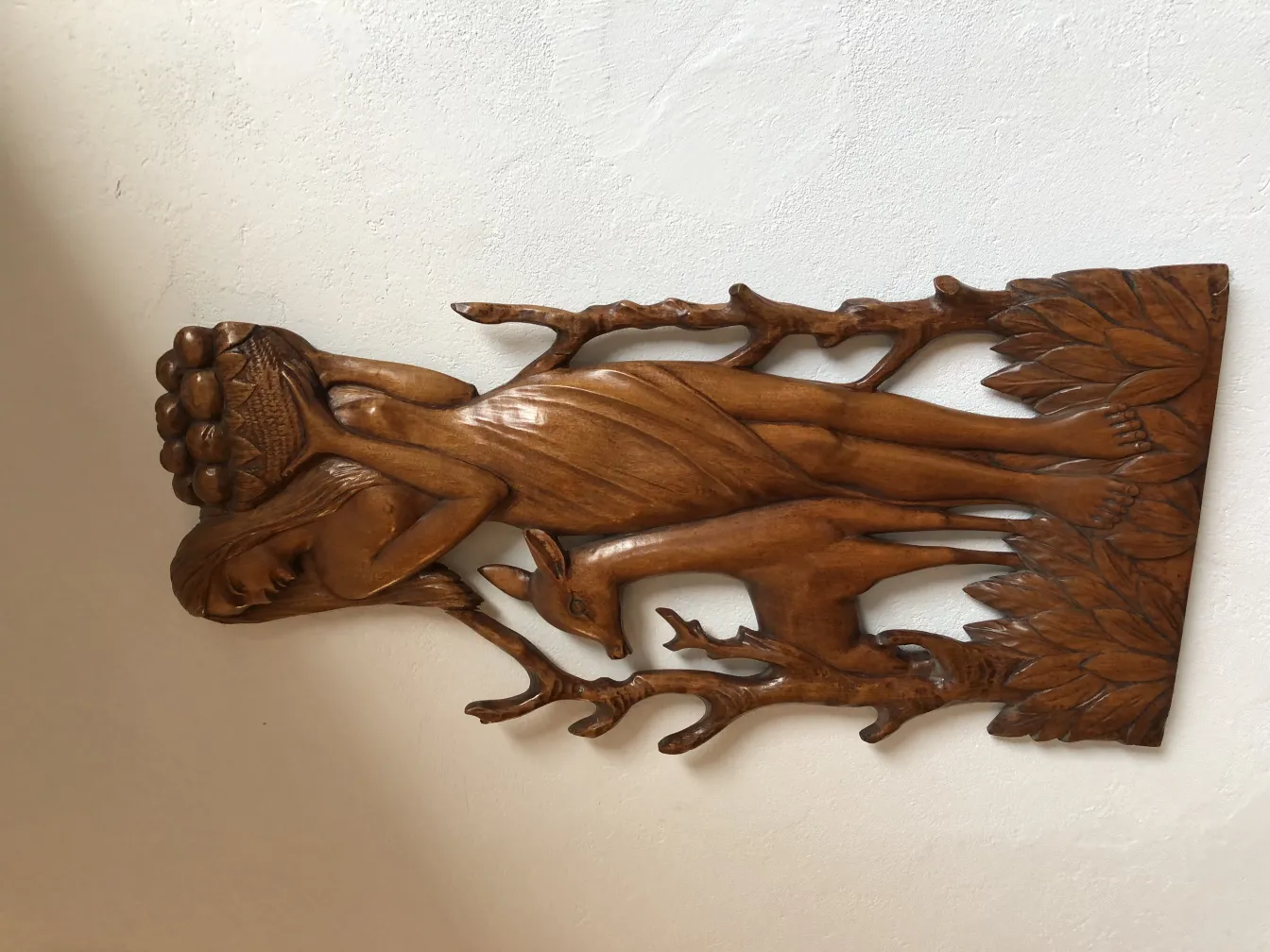 placa de parede antiga esculpida com figuras de mulher e natureza