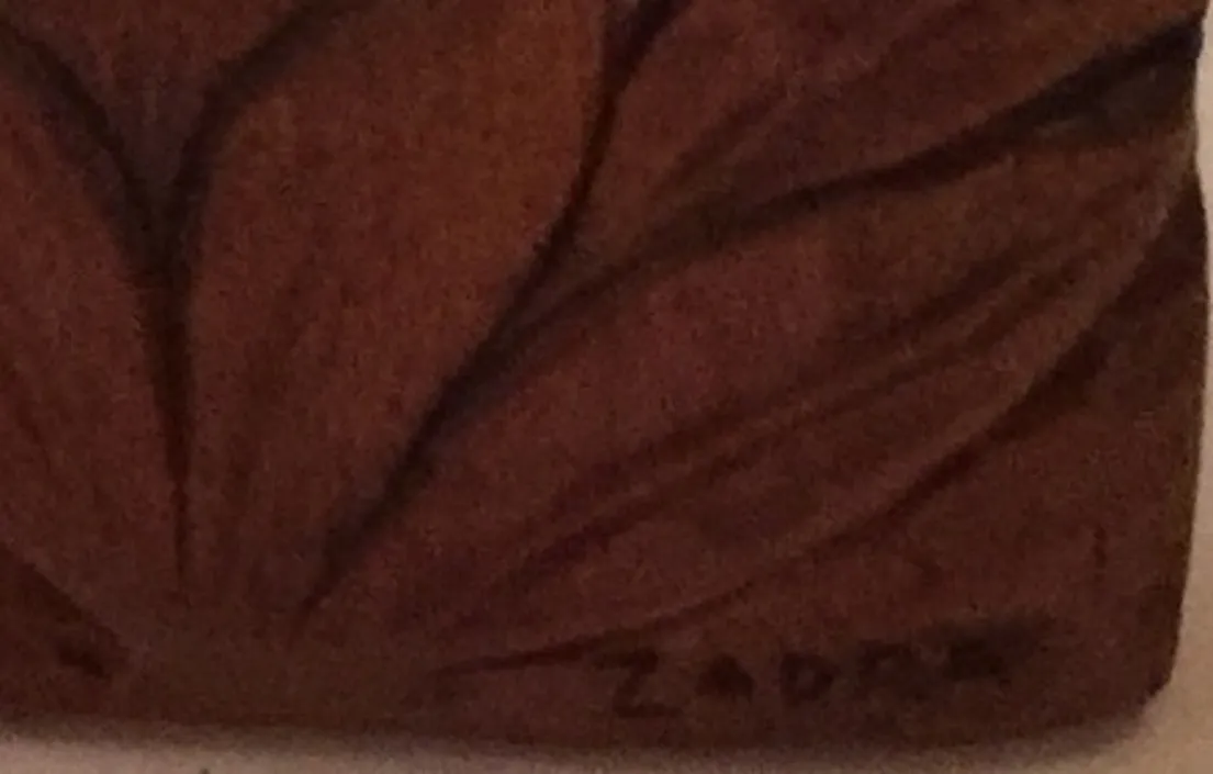 Placa de parede antiga com detalhes decorativos, assinada Zadra.