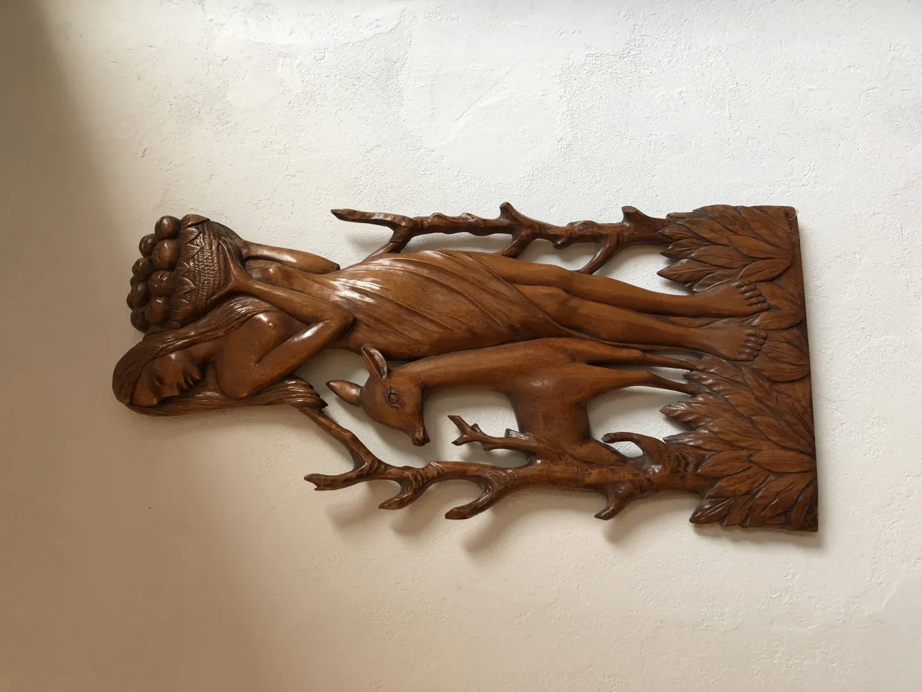 Placa de pared antigua con relieve de figura y árbol