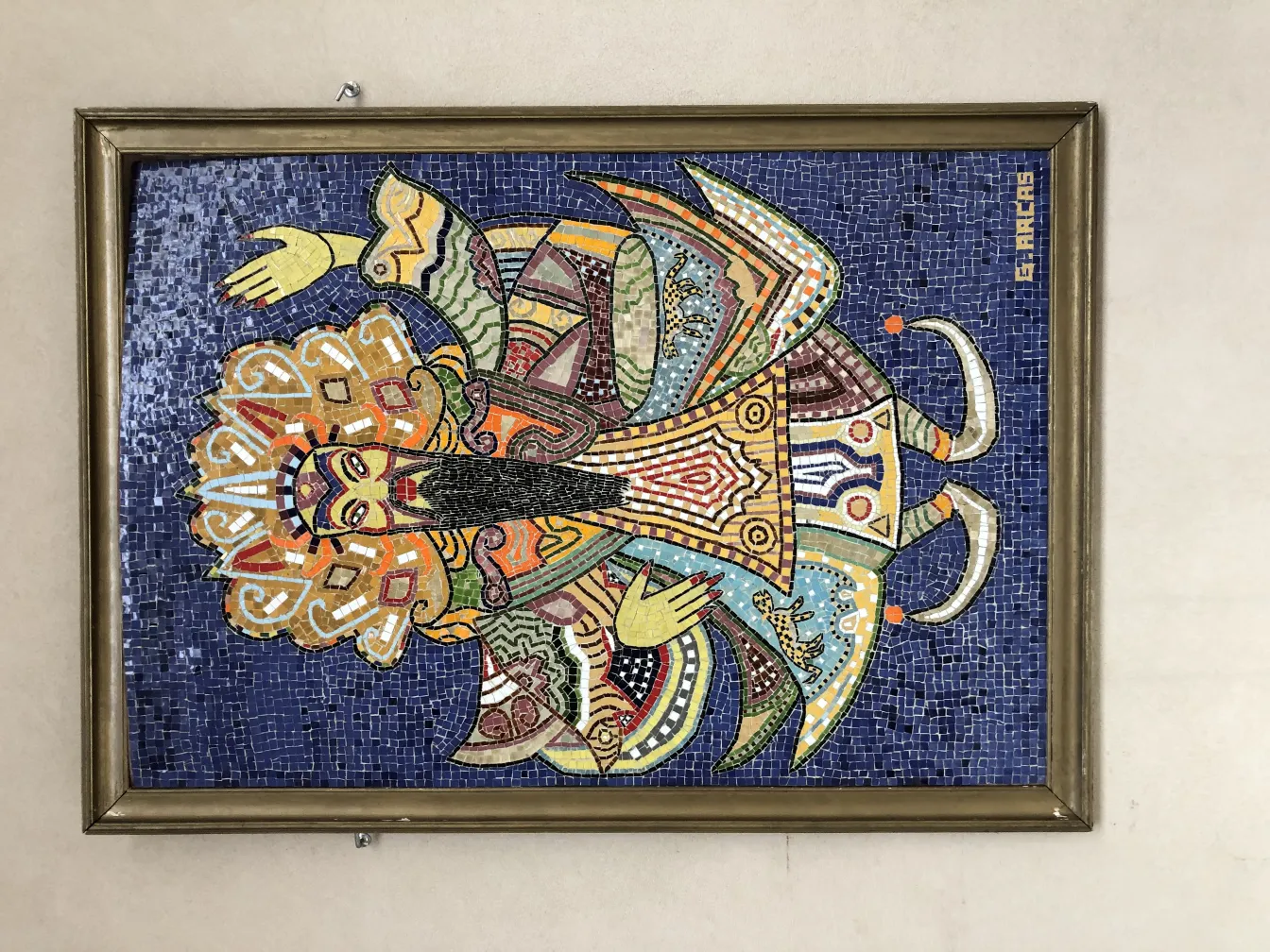 Panneau de mosaïque ancien avec un design coloré et vibrante sur fond bleu.