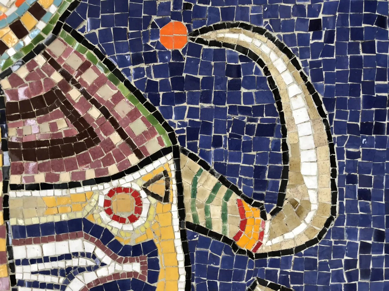 Colorful antique mosaic panel featuring various shapes in vibrant hues.