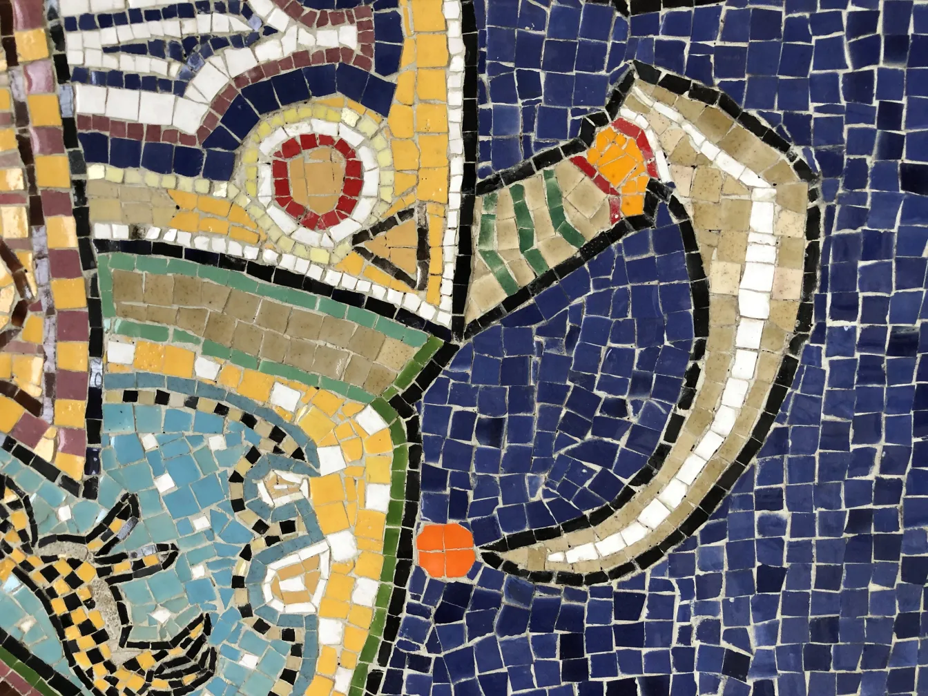 detail of an antique mosaic panel with vibrant colors and varied shapes