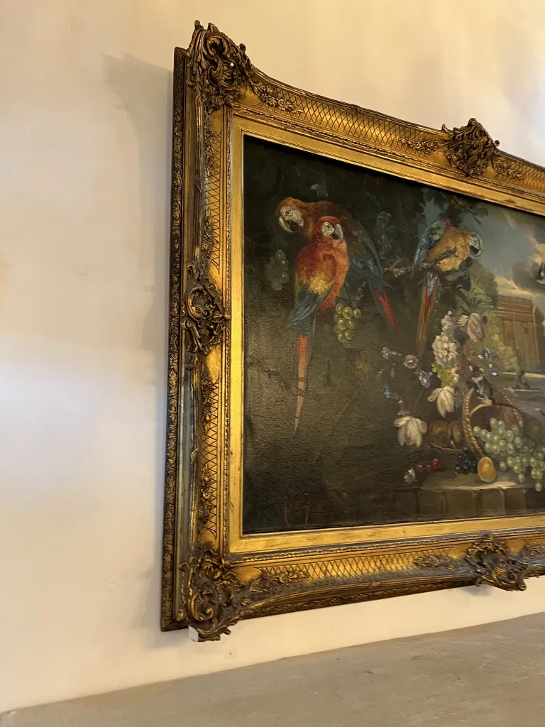 Pittura antica con cornice dorata, presenta uccelli colorati tra fiori e frutti