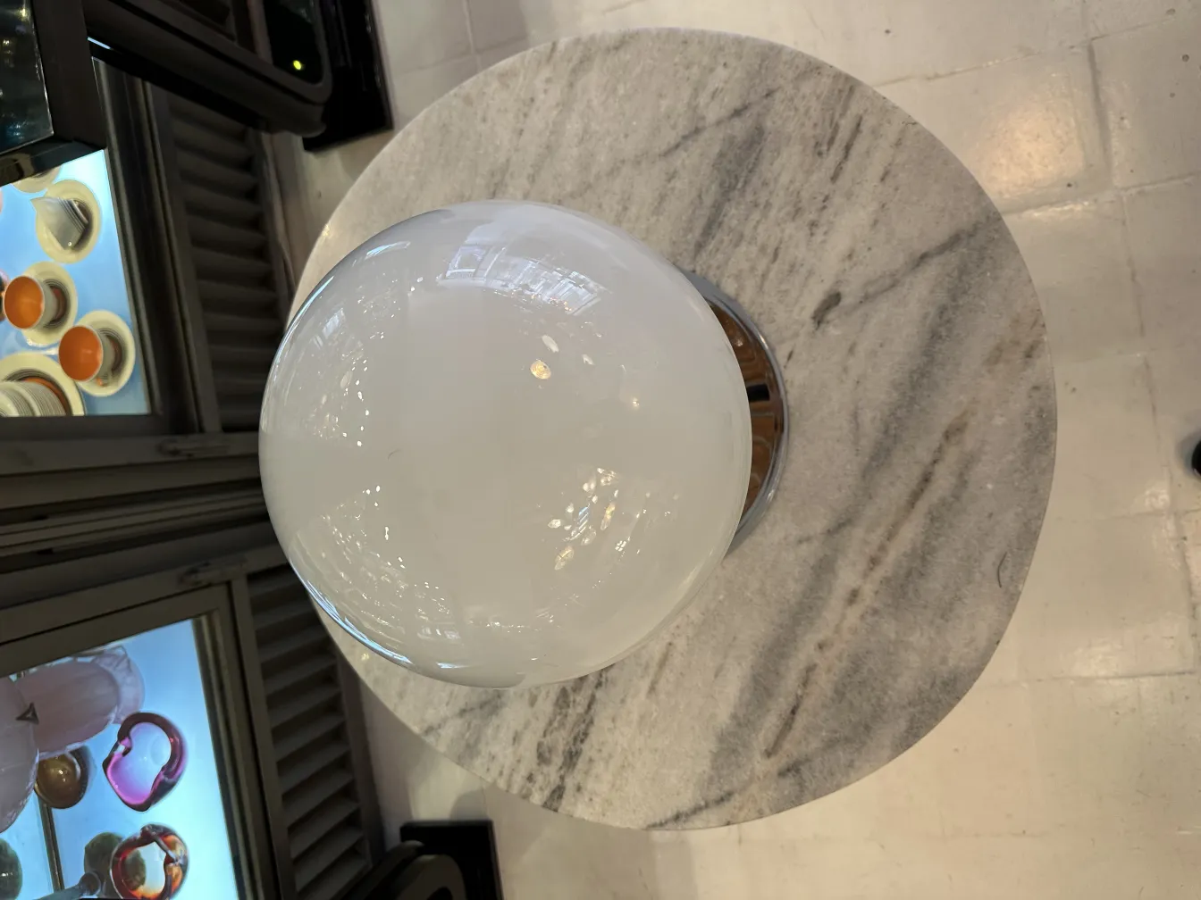 Zwei antike Tischleuchten mit rundem Design auf einem Marmortisch in einer gemütlichen Umgebung