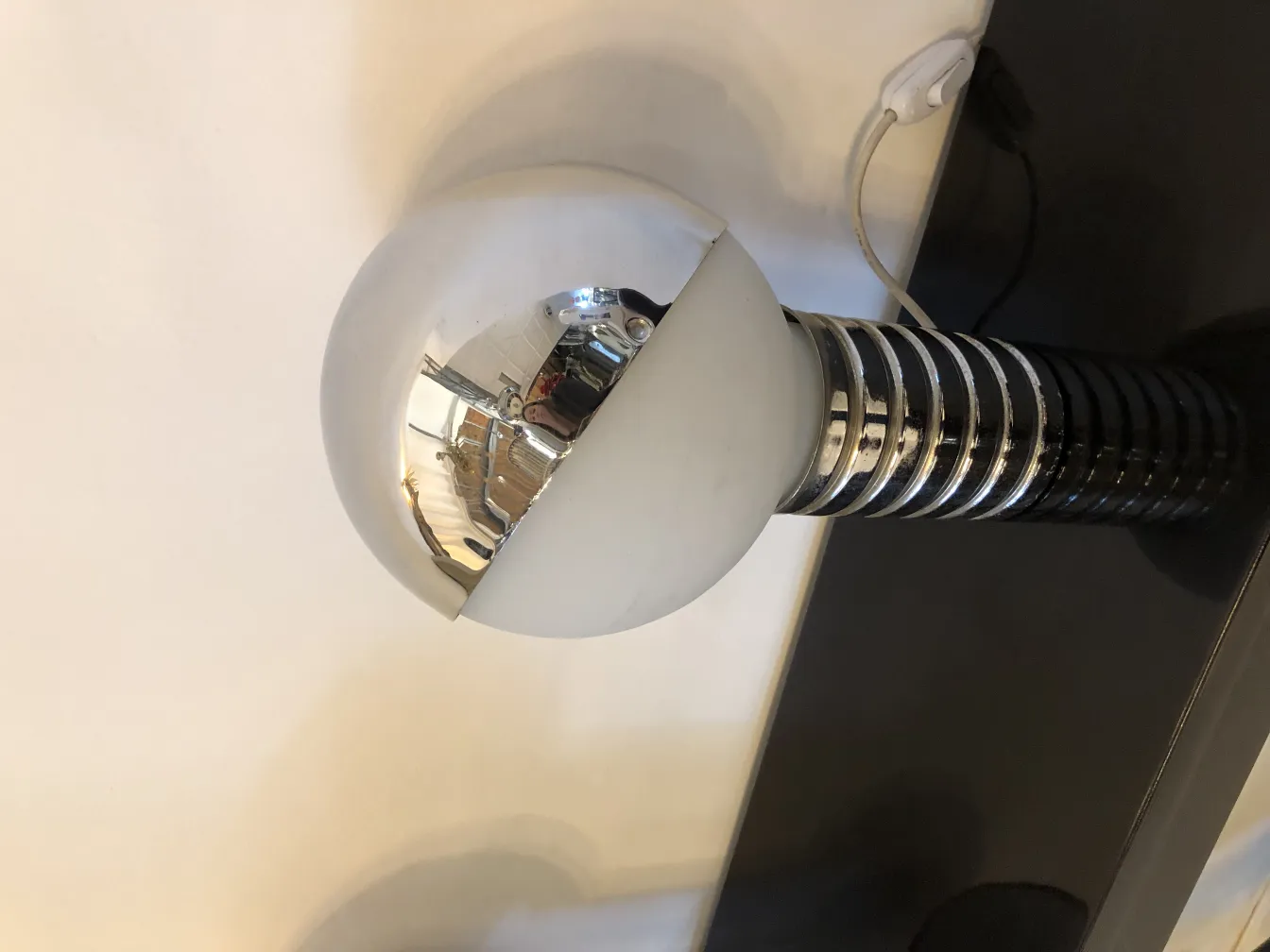 따뜻한 환경에 있는 두 개의 오래된 테이블 램프, 은색 베이스와 흰색 구형 갓이 특징입니다.