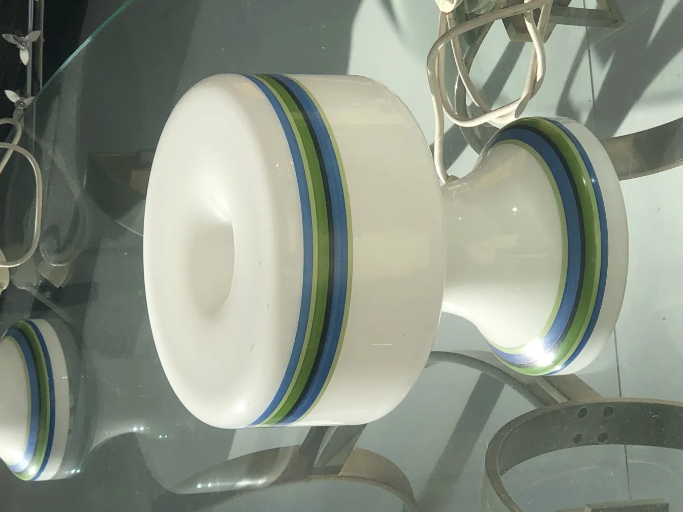 duas lâmpadas de mesa antigas com detalhes coloridos em um ambiente moderno.