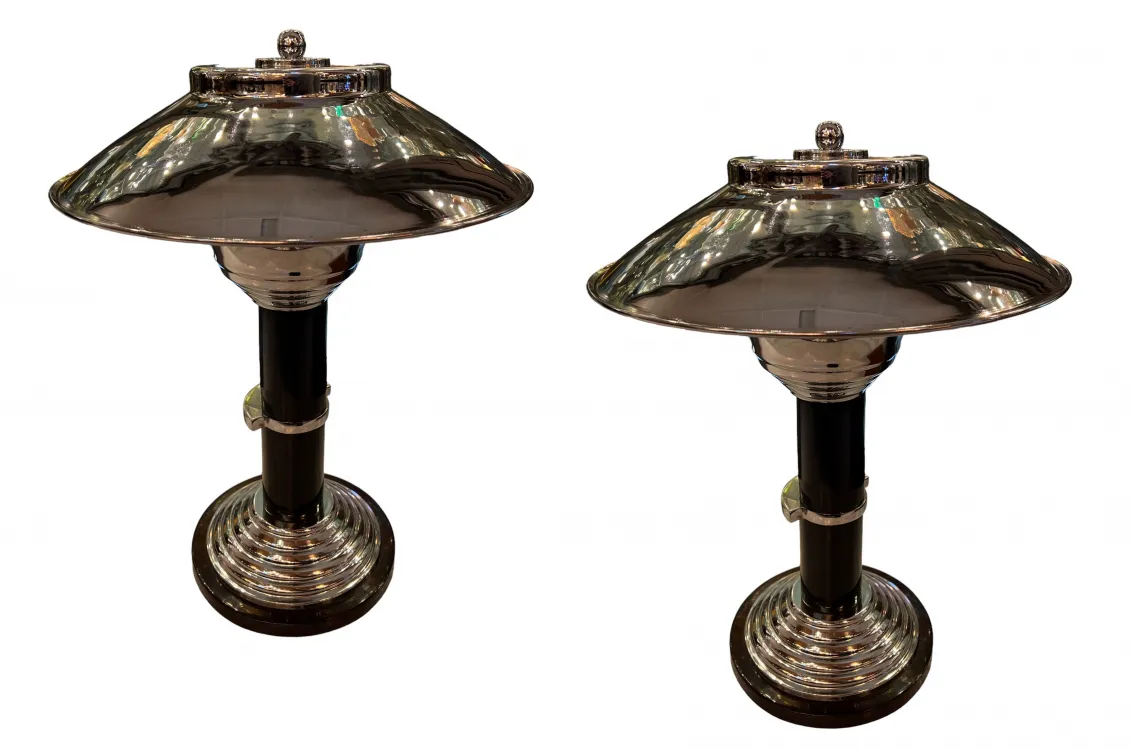 Dos lámparas de mesa antiguas con pantalla brillante y base detallada, ambientadas en un entorno clásico.