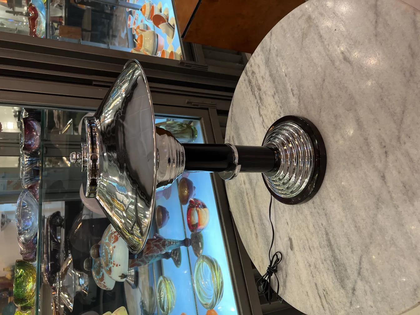 Vista de dos lámparas de mesa antiguas con base decorativa y sombrero metálico, colocadas sobre una mesa