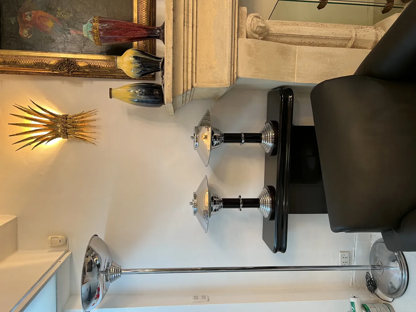 deux lampes de table antiques avec des détails brillants et une forme élégante, entourées de diverses décorations.