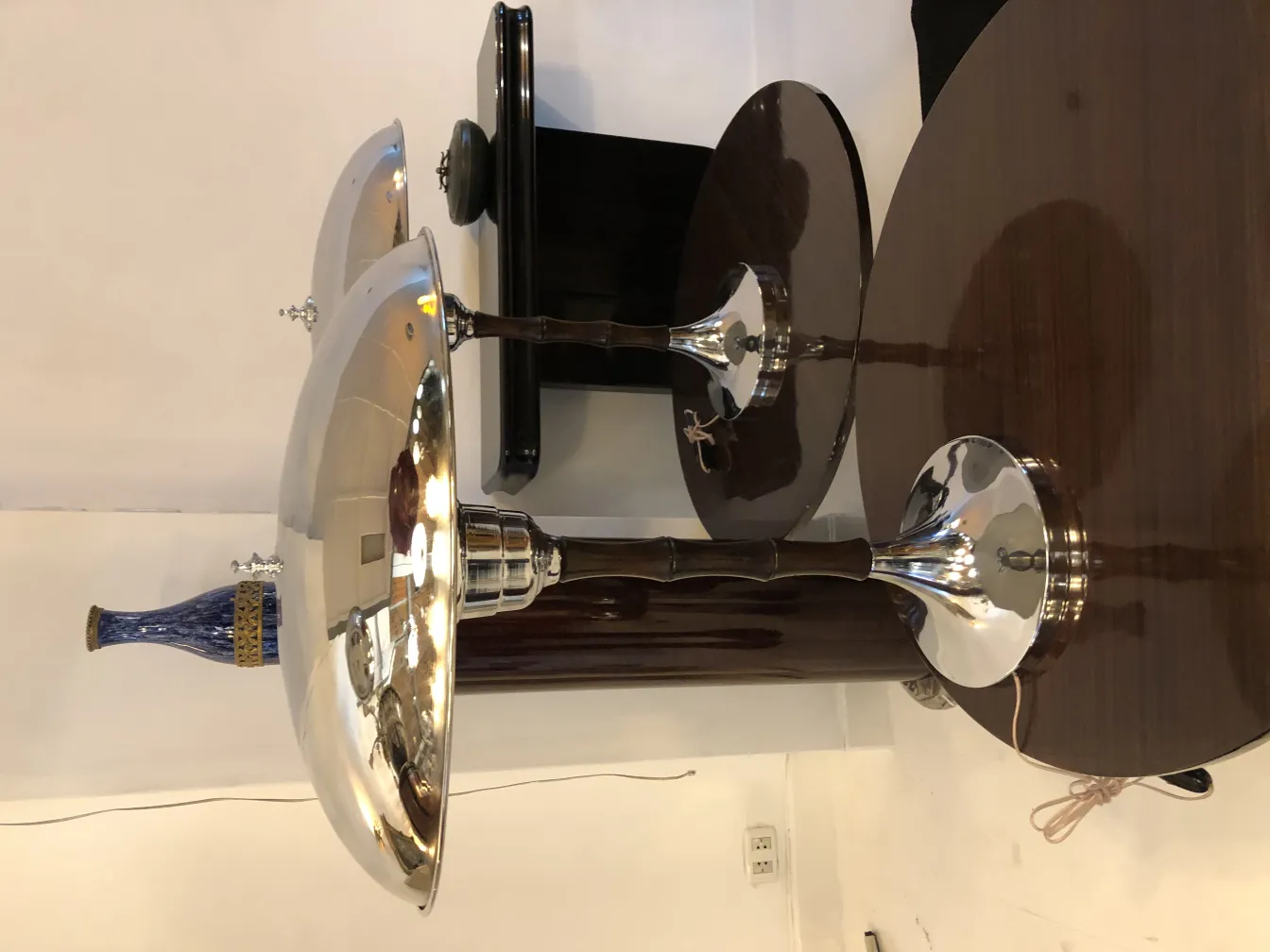 duas lâmpadas de mesa com bases brilhantes e shades largos em um ambiente neutro