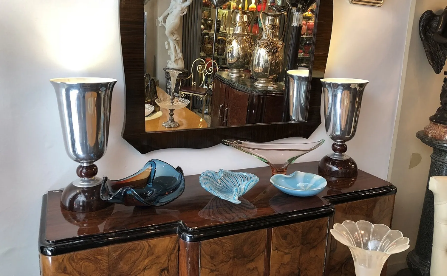 Deux lampes de table anciennes sur un meuble, reflétées dans un miroir