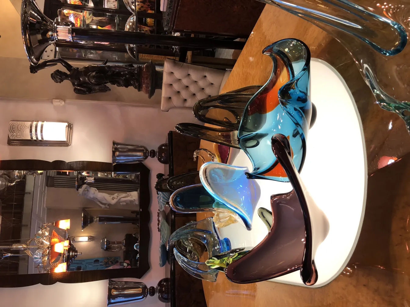 two antique table lamps on a table full of items