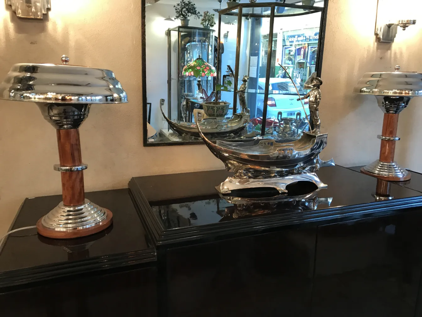 dos lámparas de mesa antiguas y brillantes sobre un mueble negro