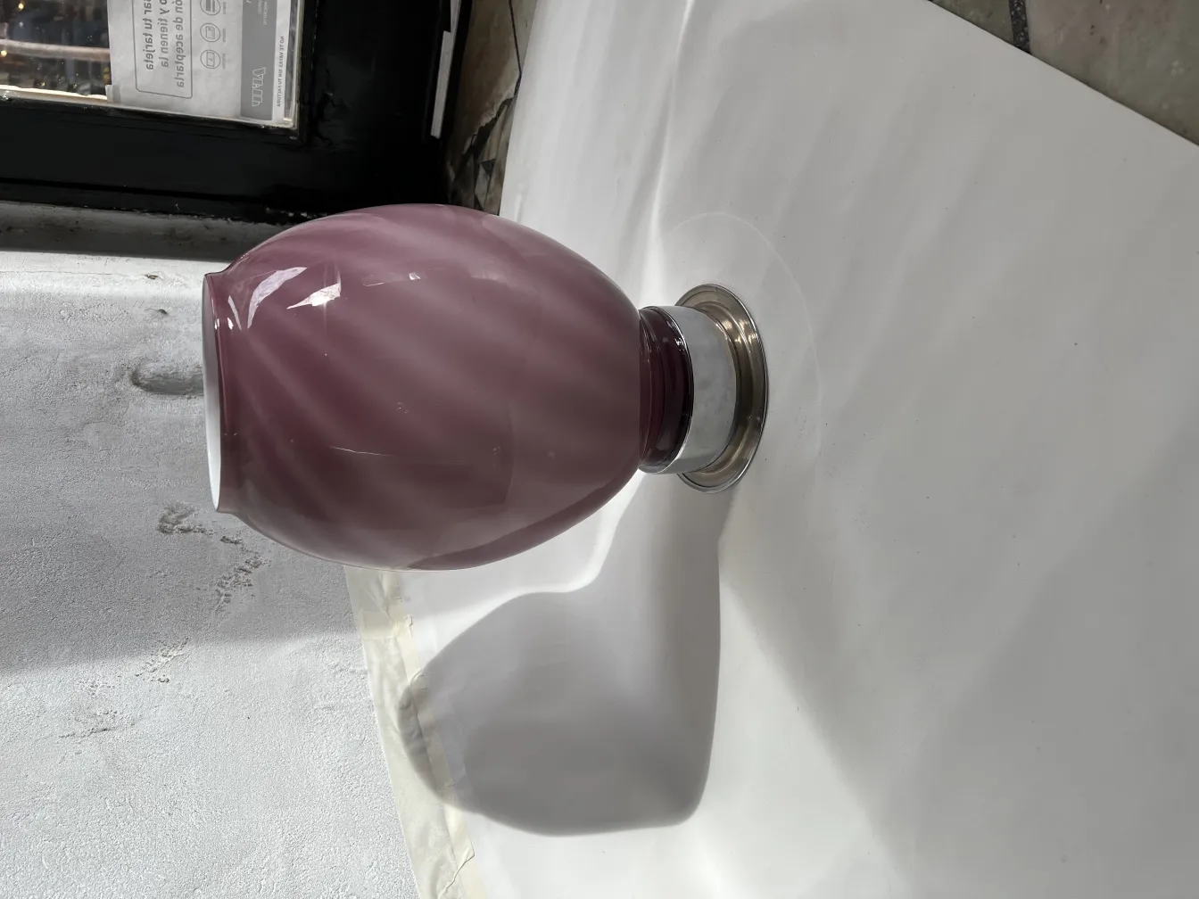 2 antique table lamps with a metallic base and curved purple design in a neutral setting.