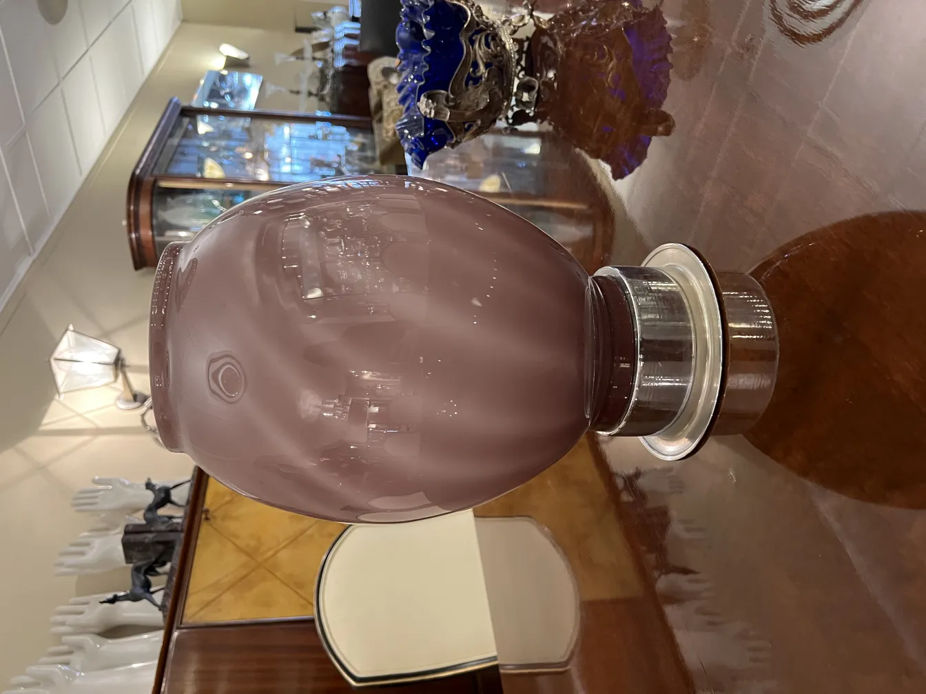 due lampade da tavolo antiche con base in ceramica in un ambiente elegante con vetrine sullo sfondo