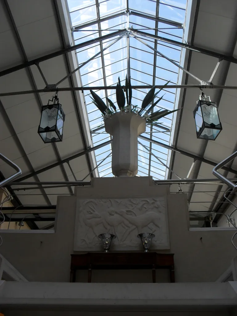 Two antique table lamps enhancing a well-lit space with a large glass ceiling.