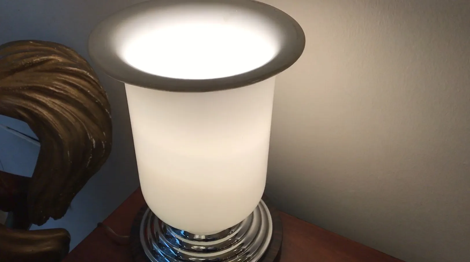 Antica lampada da tavolo bianca con base lucida in un contesto accogliente.